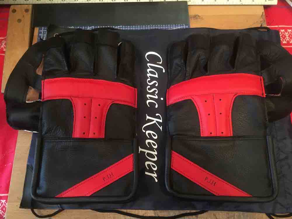 Black and red wicket keeping gloves