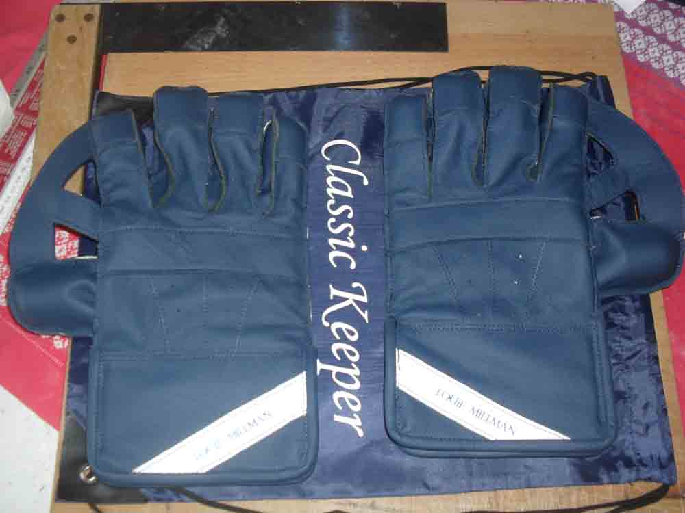 Blue wicket keeping gloves with white name tags